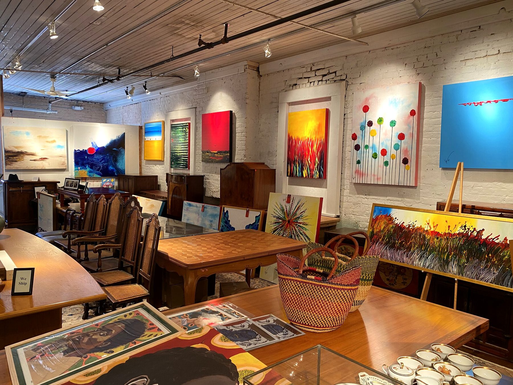 Bright Vincent Golshani paintings along the white brick walls of Goldon House Gallery