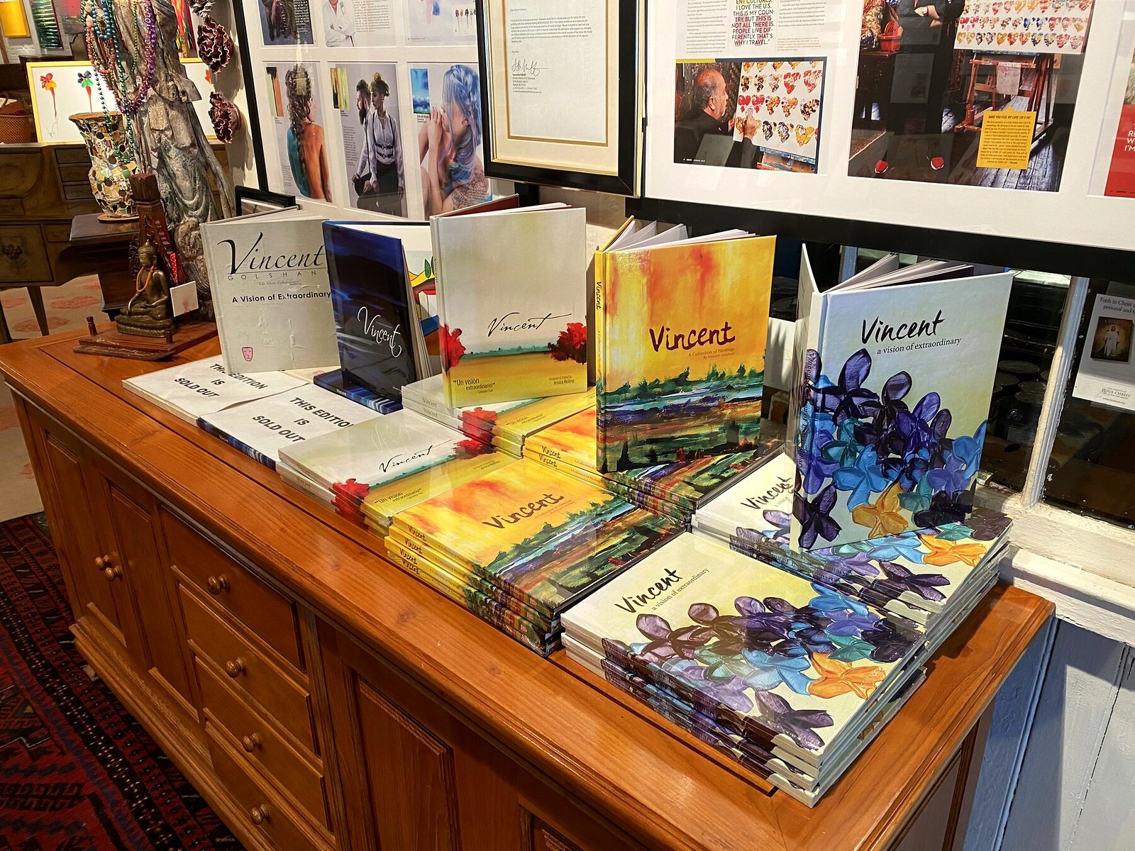 Vincent Golshani coffee table books stacked on an antique chest in Goldon House Gallery